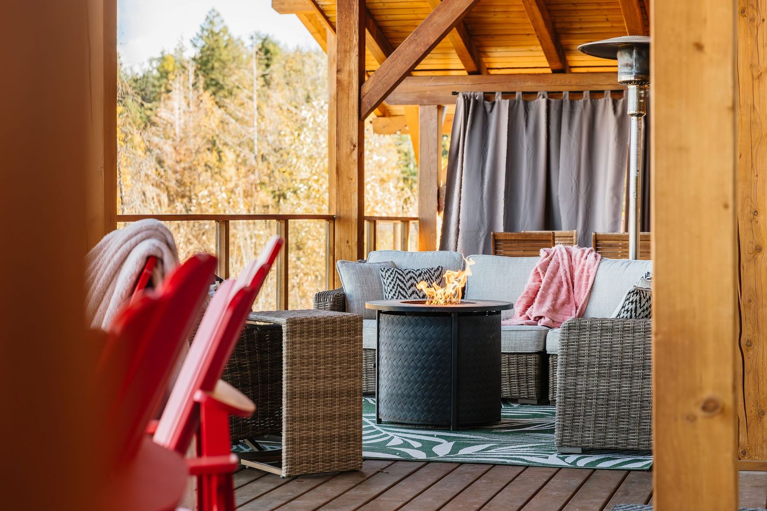 A rustic wooden porch with exposed beams and hanging red and white striped decorative elements.