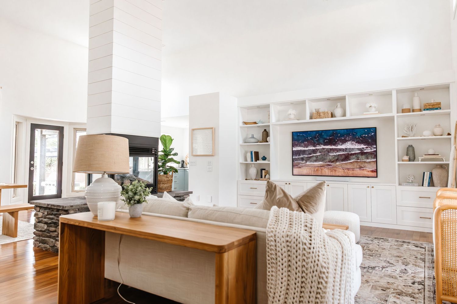 Spacious white living room with built-in shelving and contemporary furnishings.