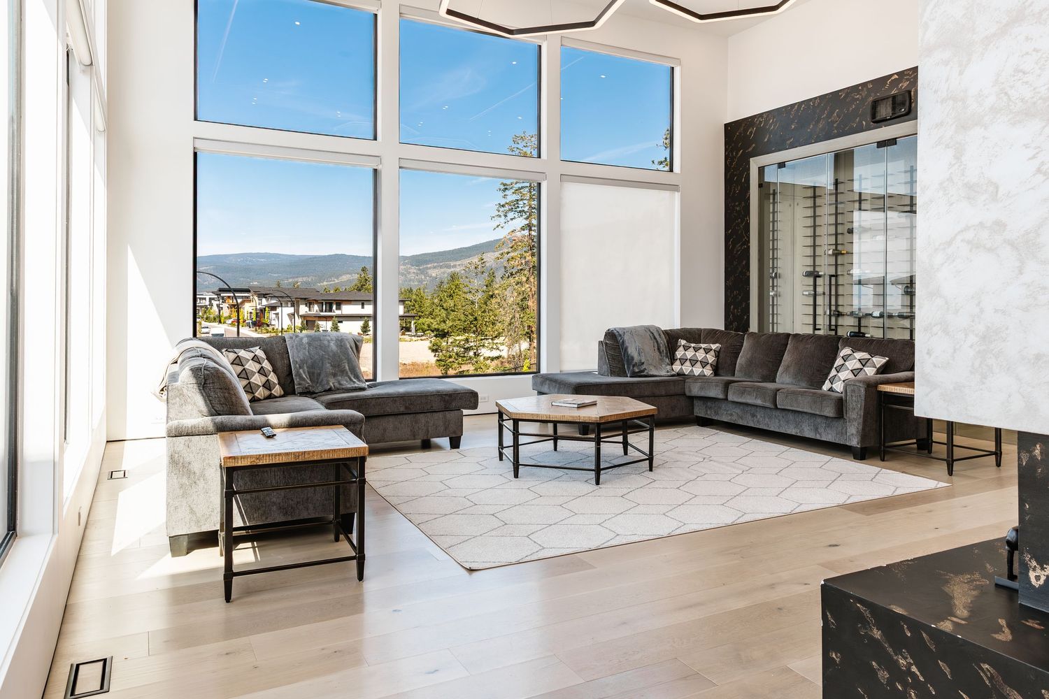 Open concept living space with large windows, modern furniture, and tile flooring in a west Kelowna Airbnb