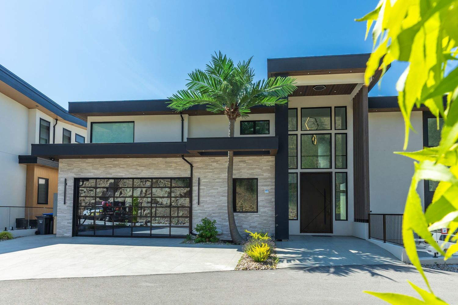 Contemporary white house exterior with black accents and large windows in a modern architectural style outside a west Kelowna Airbnb