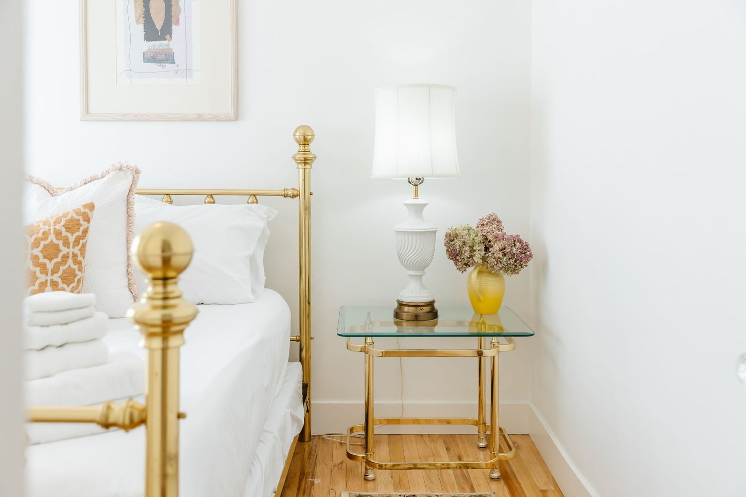 Luxurious bedroom featuring gold accents and white bedding.