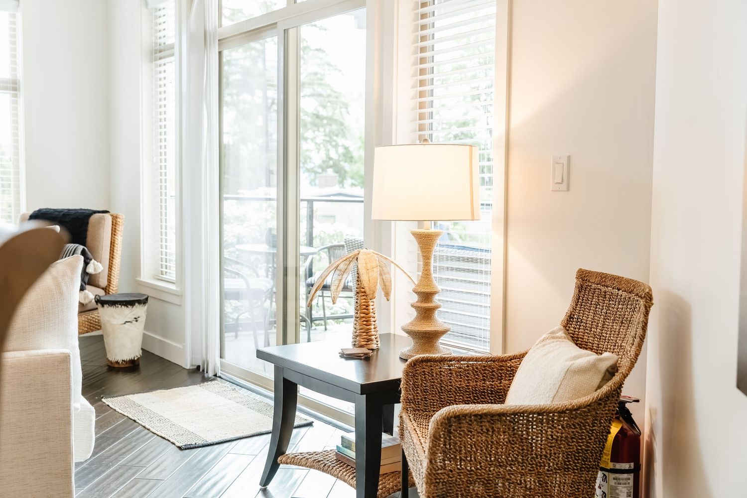 Bright living area with large windows, wicker chair, and natural light streaming in in a west Kelowna Airbnb