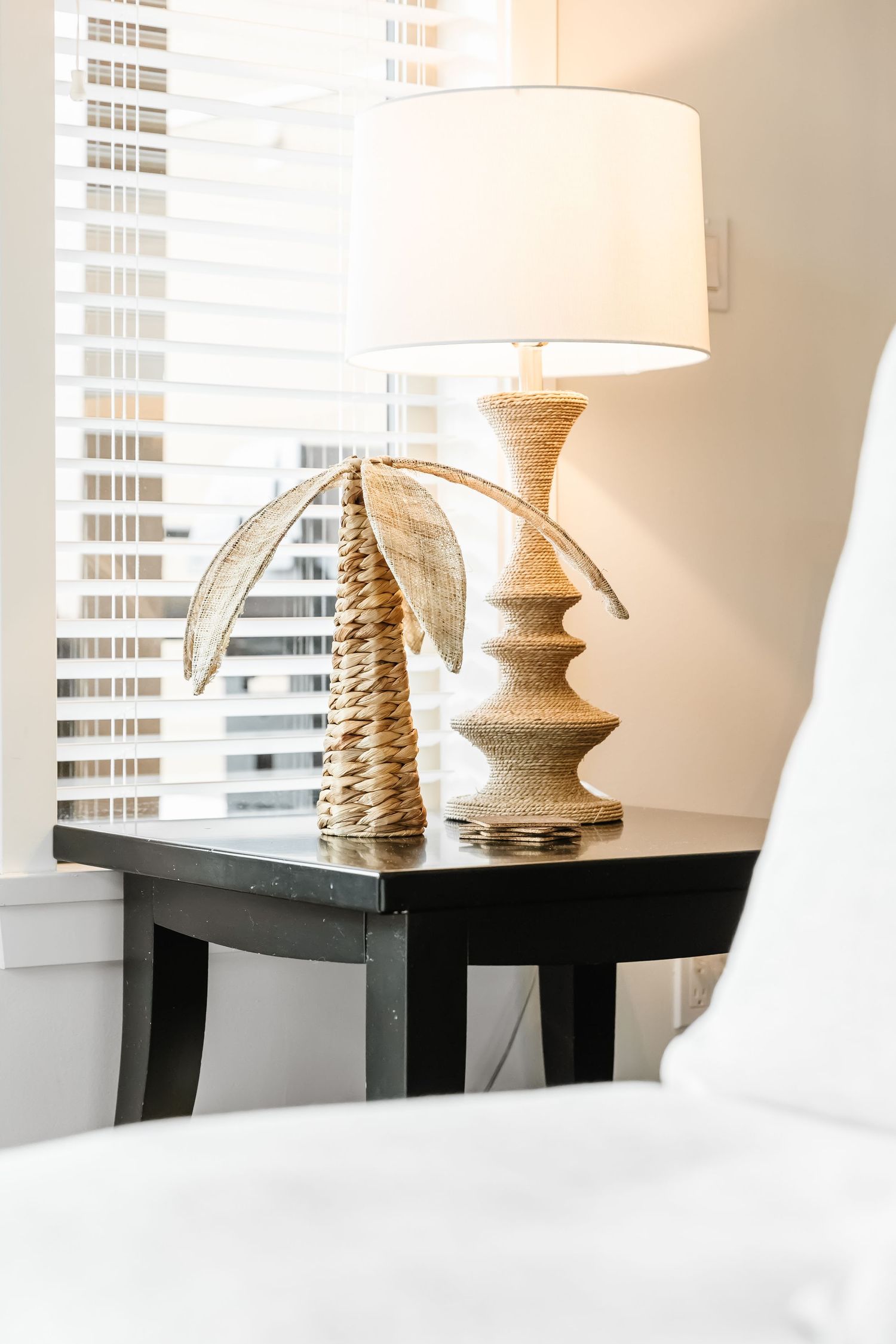 Decorative table lamps with rope-textured bases displayed on a dark console table near white blinds in a west Kelowna Airbnb