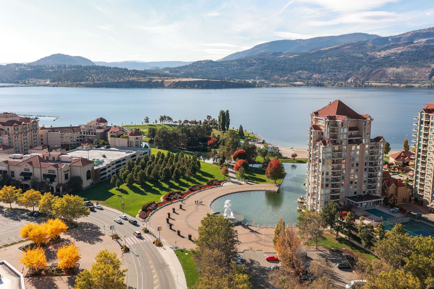 Aerial view of waterfront development with fall colors and curved shoreline.