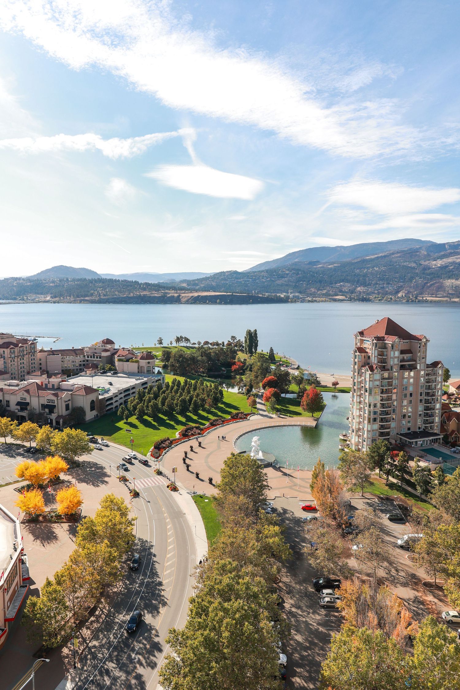 Scenic overlook of lakeside community with autumn trees and residential buildings.