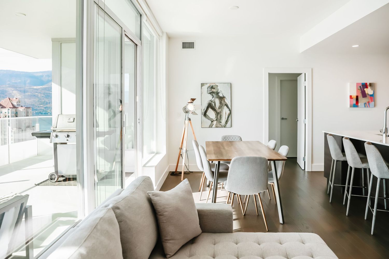 Bright modern interior with floor-to-ceiling windows and contemporary white furnishings.