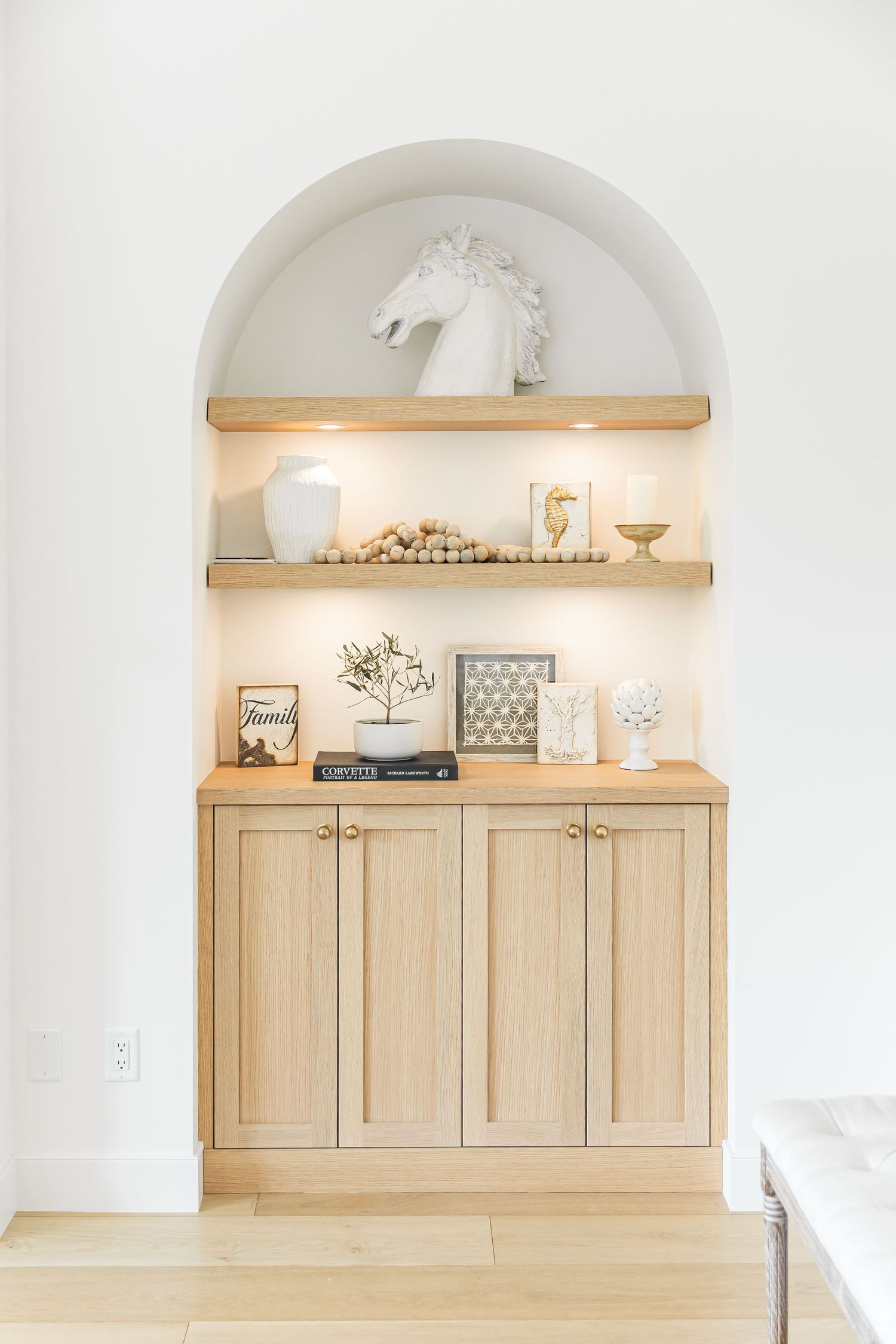 Light and airy kitchen featuring white cabinets, wooden shelving, and arched alcove details in a west Kelowna Airbnb