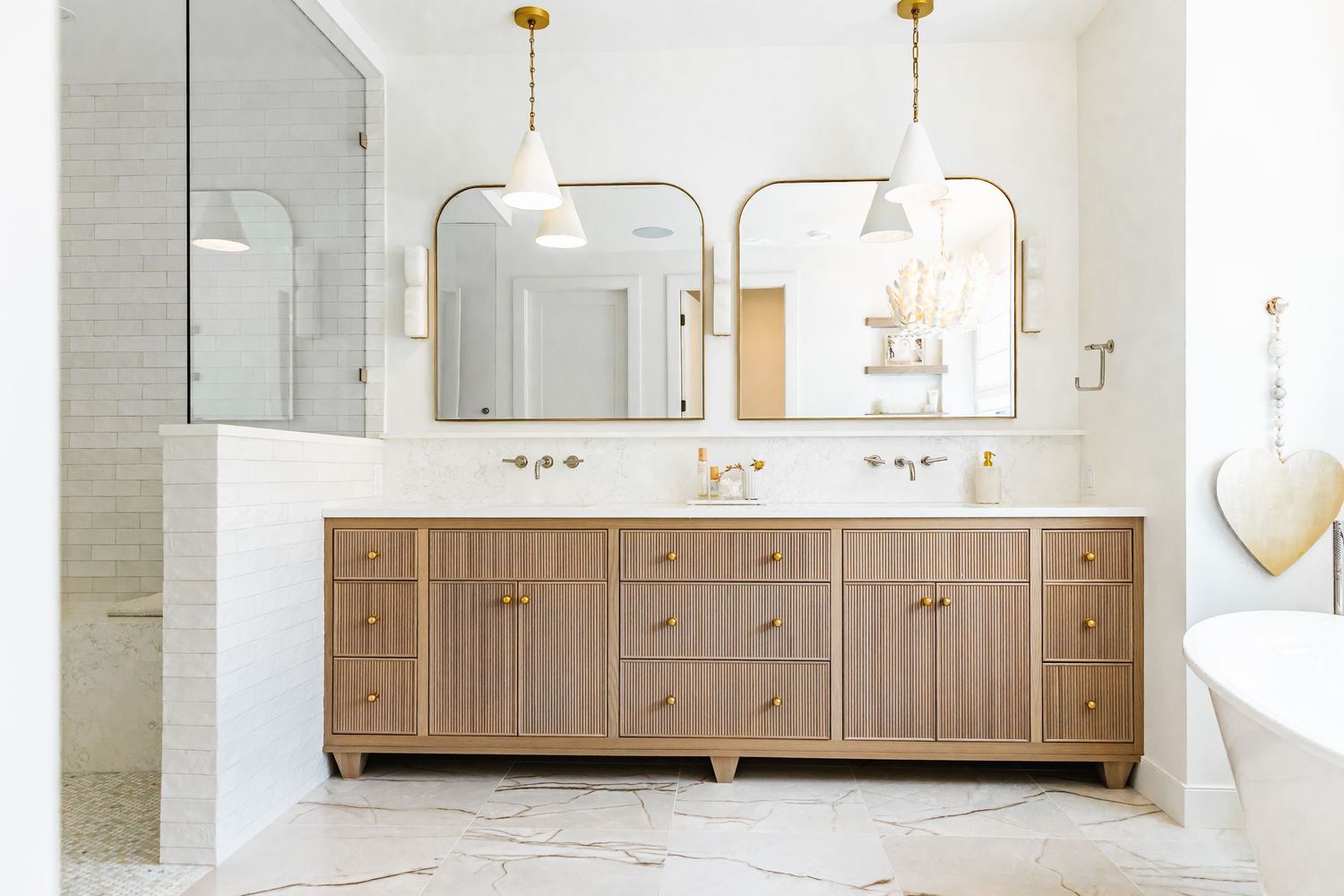 Luxurious bathroom with double vanity, gold fixtures, and floor-to-ceiling mirrors in a west Kelowna Airbnb