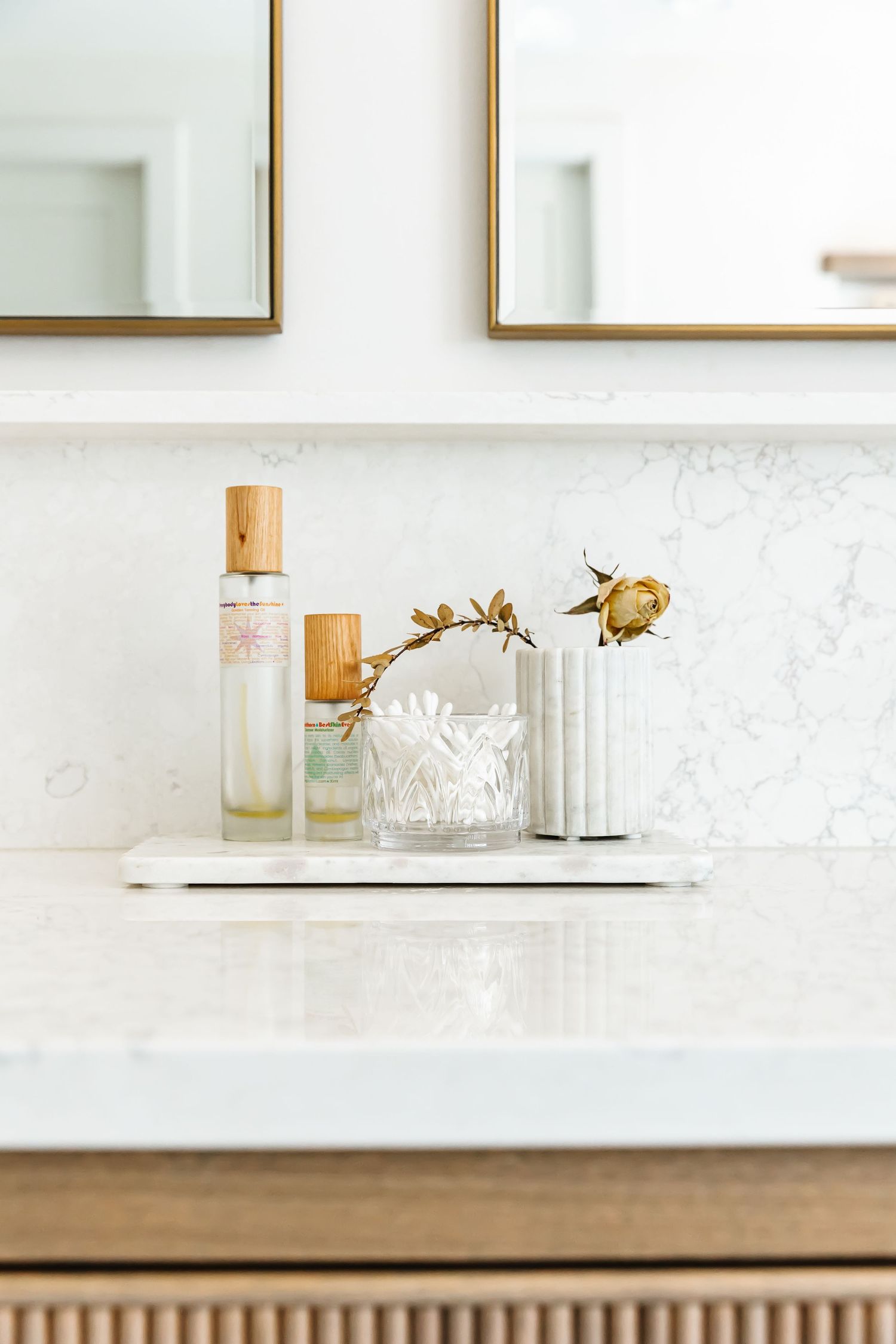 Marble countertop with gold-framed mirror and decorative accessories in a modern bathroom in a west Kelowna Airbnb