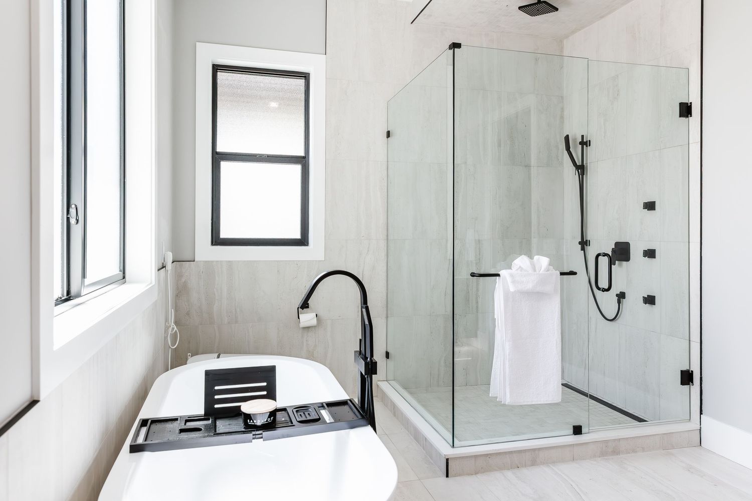 Minimalist white bathroom featuring glass shower enclosure and modern fixtures  in a west Kelowna Airbnb