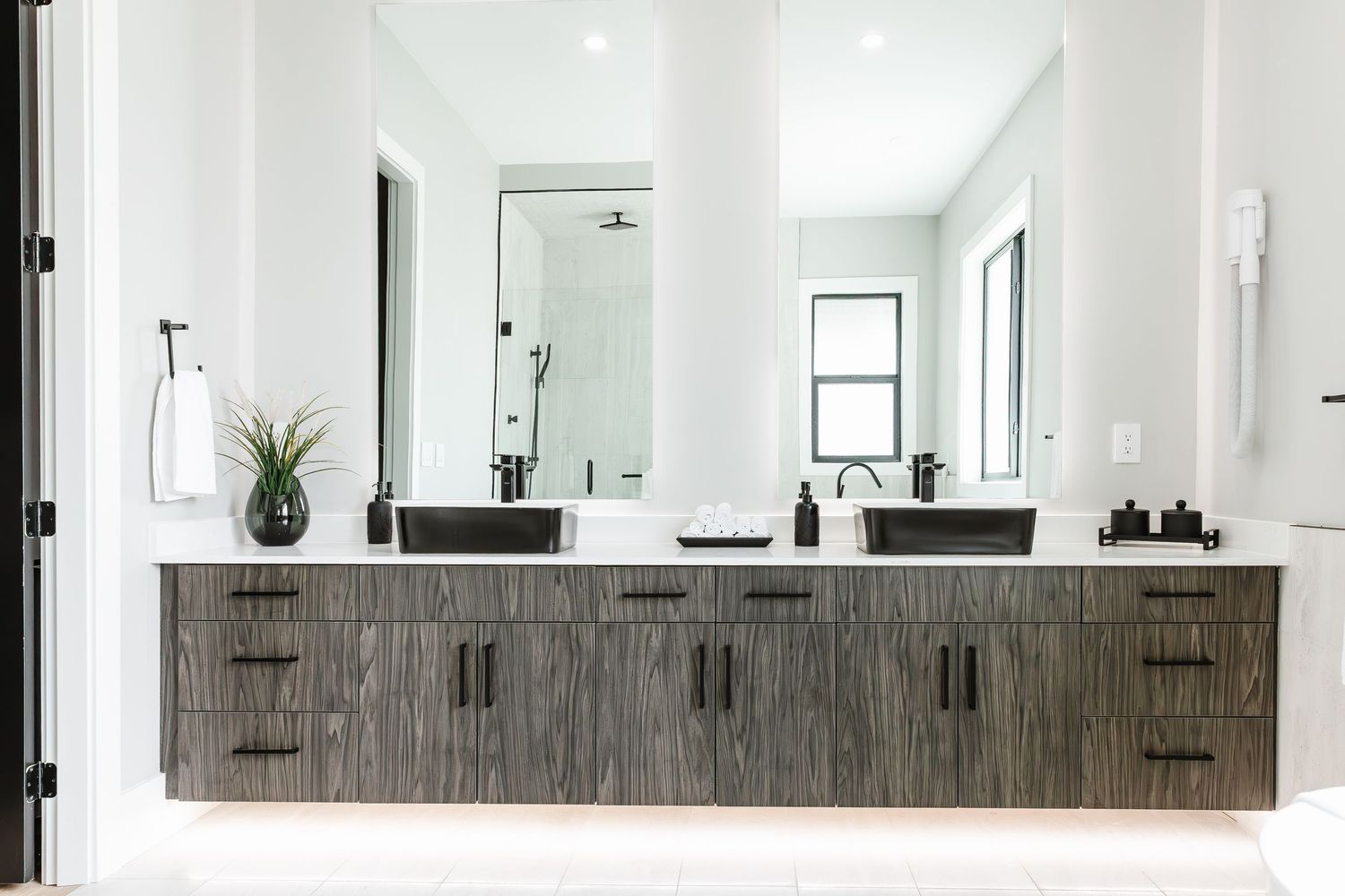 Long modern bathroom vanity with dark wood cabinets and dual sinks  in a west Kelowna Airbnb
