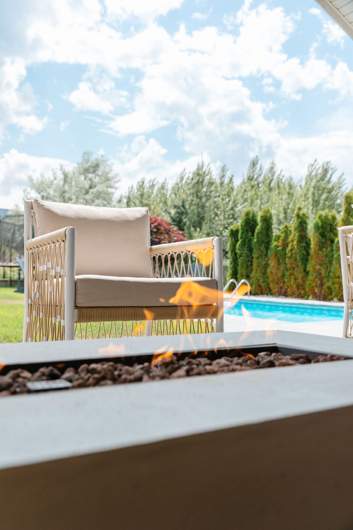 Outdoor patio area with pool view, privacy fence, and comfortable lounge furniture.