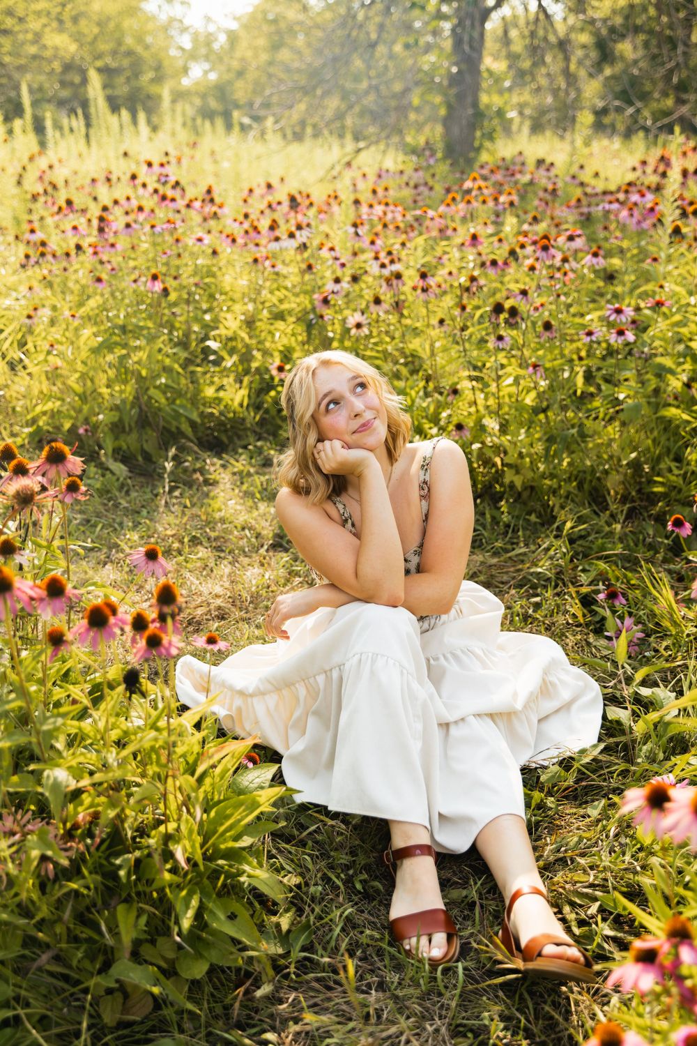 A dreamy summer portrait in a wildflower meadow filled with pink coneflowers and golden evening light.