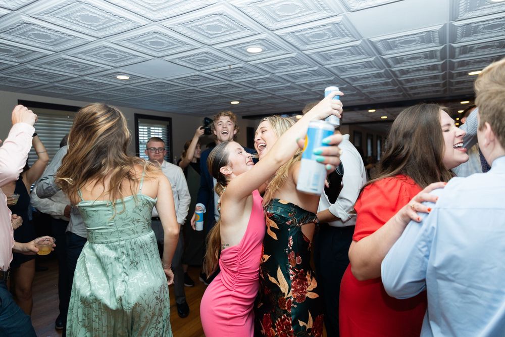 People dancing and celebrating together at a lively indoor party or reception event.