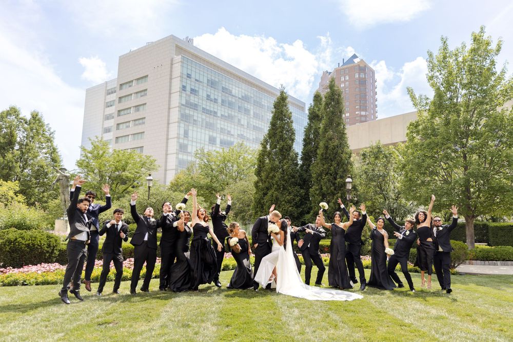 Wedding party celebrating on the lawn of the Des Moines, Iowa World Food Prize downtown. Iowa wedding venue and photography