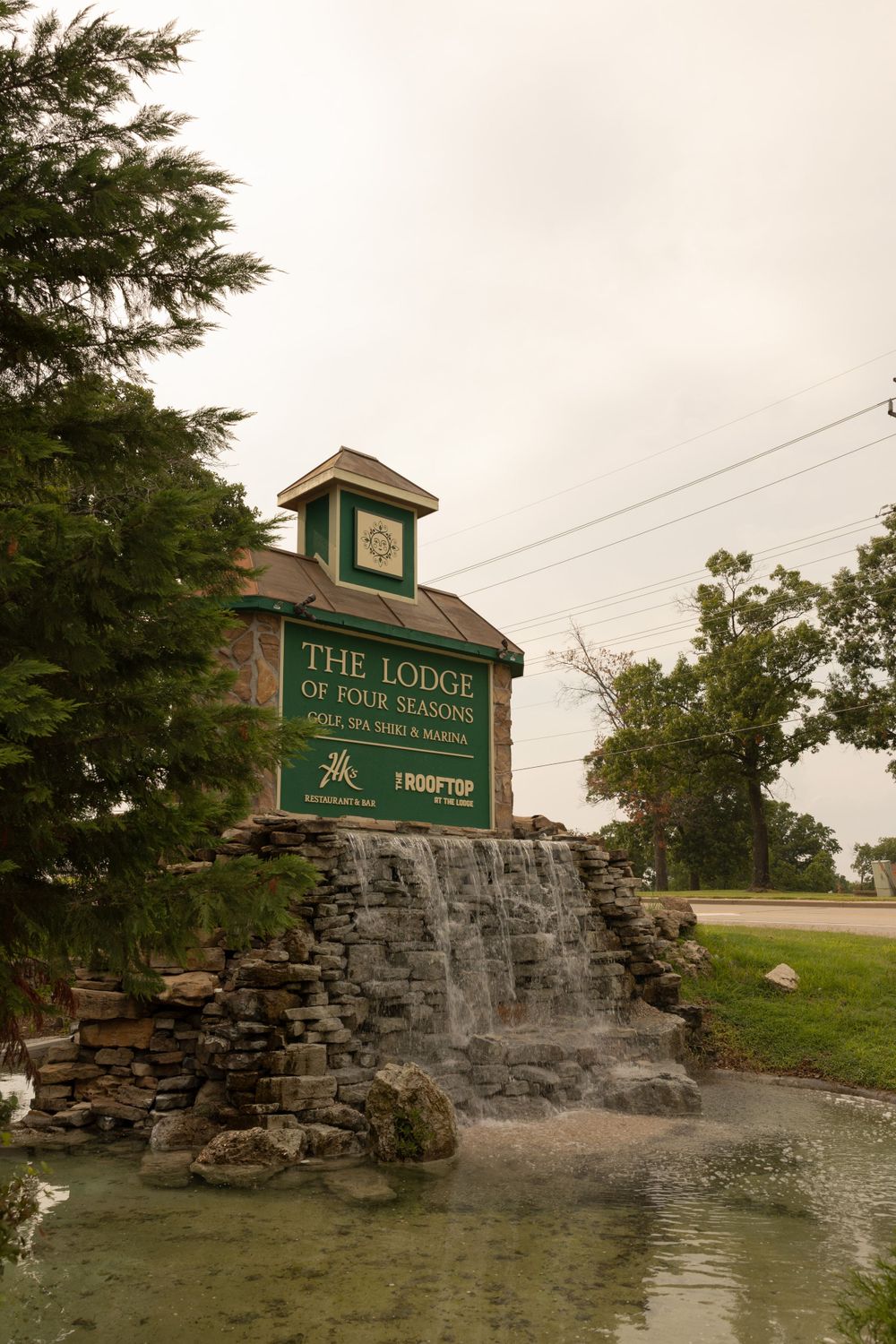 The Lodge entrance sign with a decorative stone waterfall feature in the foreground.