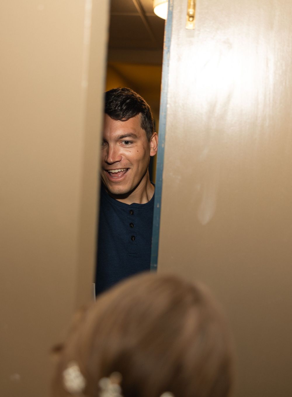 A playful peek through a partially opened doorway during event preparations.
