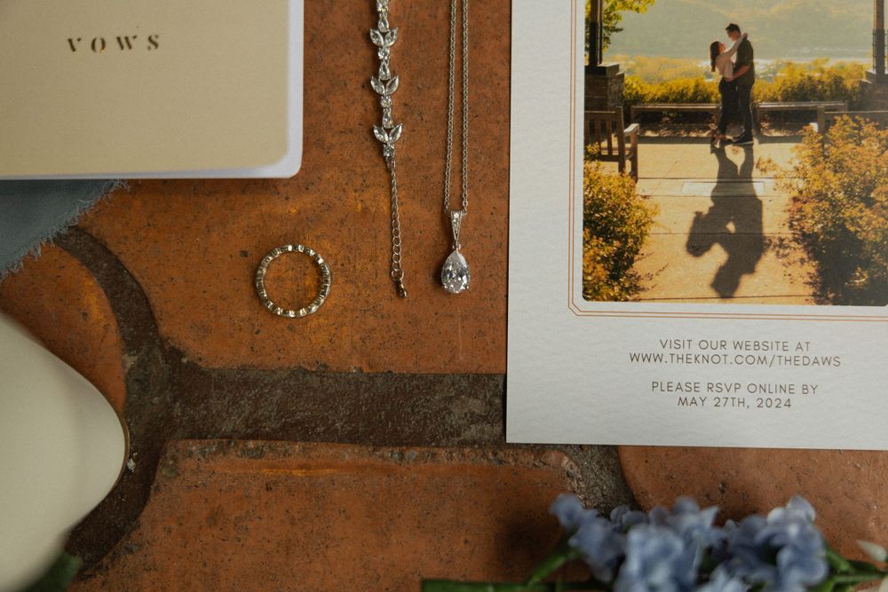 Wedding accessories and jewelry arranged on a leather surface with a vintage photograph.