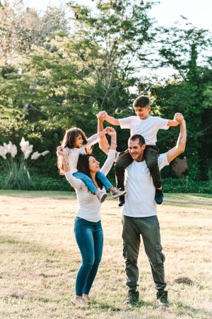 Family playing and having fun together in a sunny outdoor field.