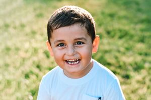 Joyful outdoor portrait against natural grass background.