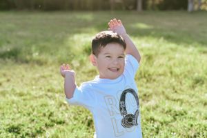 Joyful outdoor moment in grassy field with sunlight creating natural warmth.