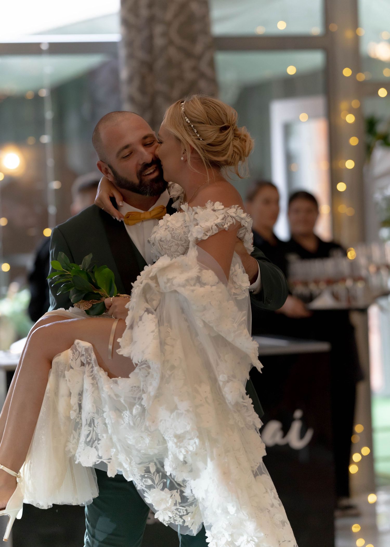 A joyful wedding dance moment showcasing an elaborate lace wedding gown.