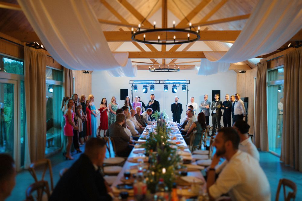 Wedding reception venue interior with elegant chandeliers and decorative ceiling details.