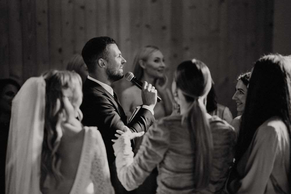 Dance floor filled with guests enjoying a celebration in a dimly lit venue.