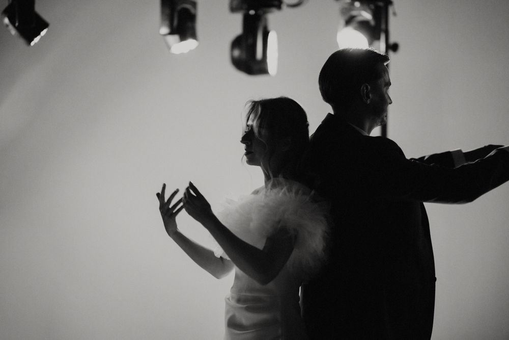 Silhouettes of people dancing under dramatic lighting at an event.