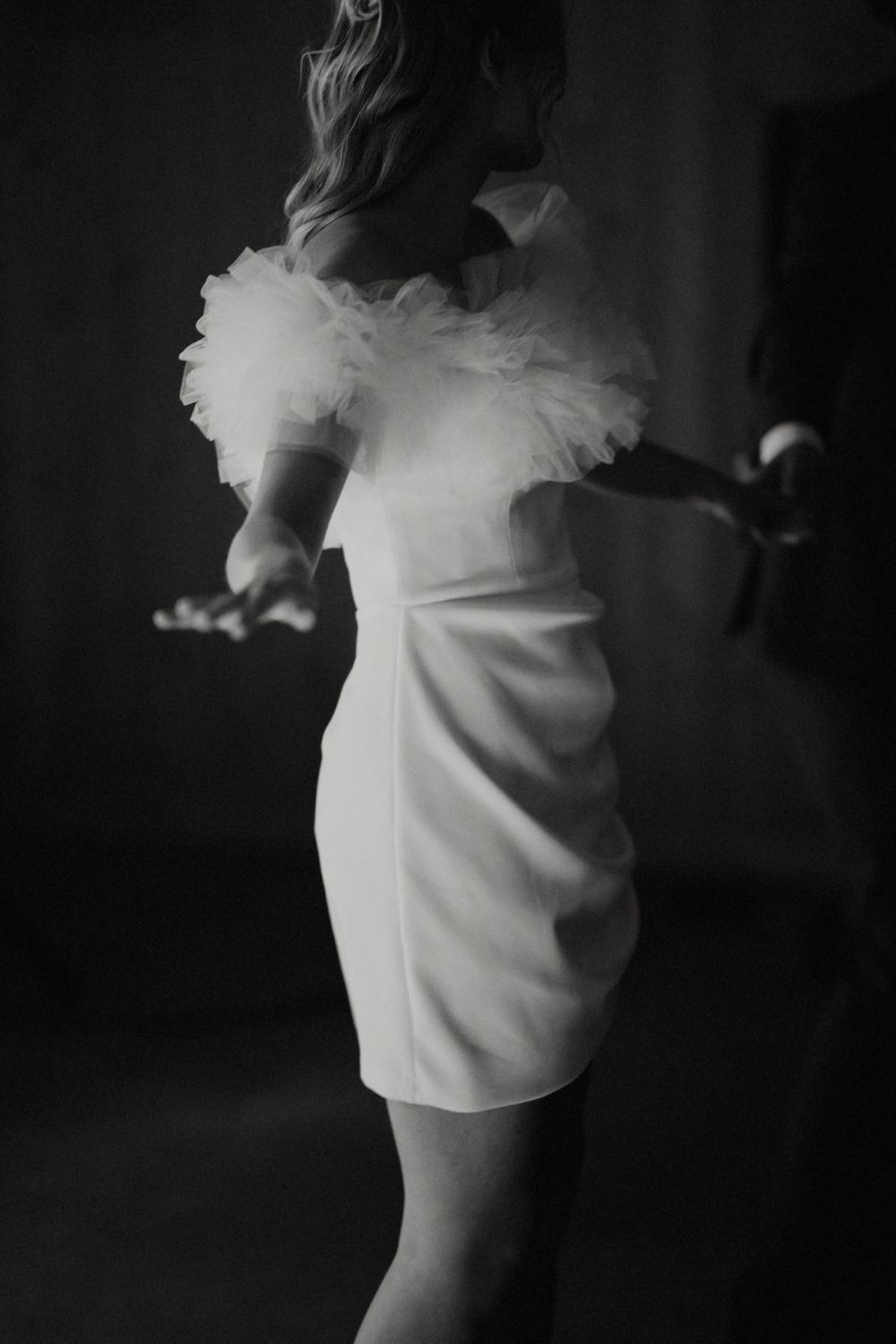 Black and white photo of dancers in flowing white dresses creating artistic movement.