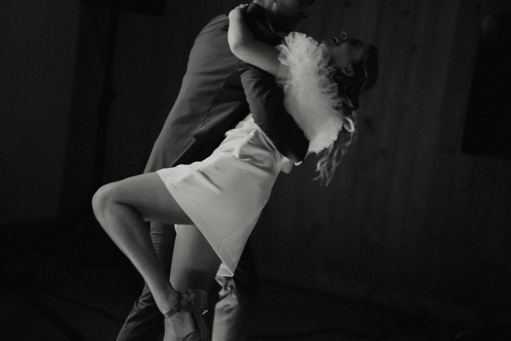 Couples dancing together at a wedding reception in low light conditions.