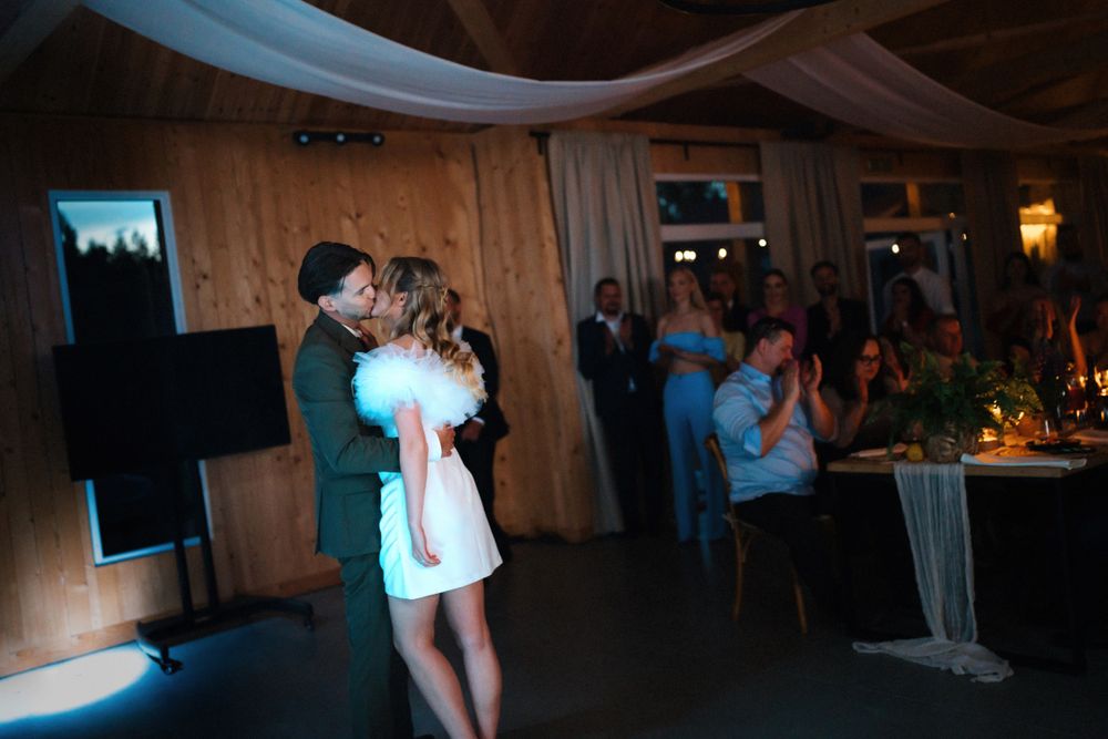 Wedding reception dance floor with rustic wood paneled walls and ambient lighting.