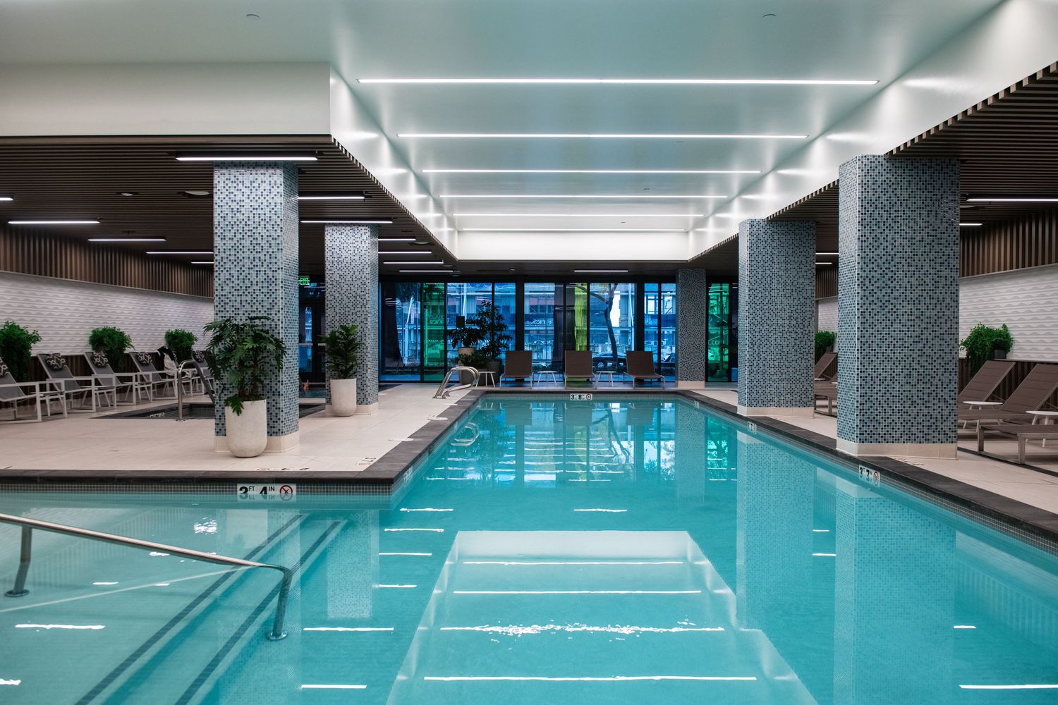 Modern indoor swimming pool with sleek design and ambient lighting.
