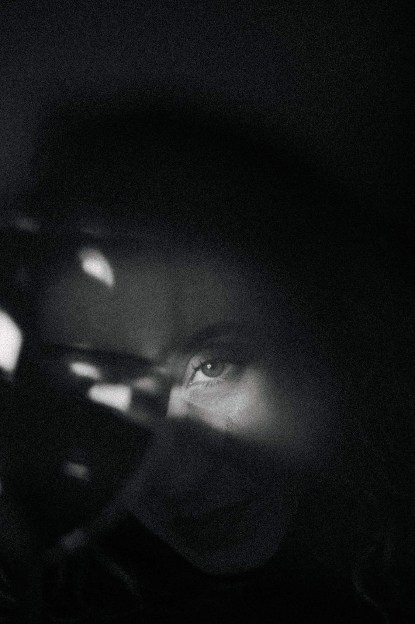 Abstract black and white photograph with mysterious light patterns in darkness.