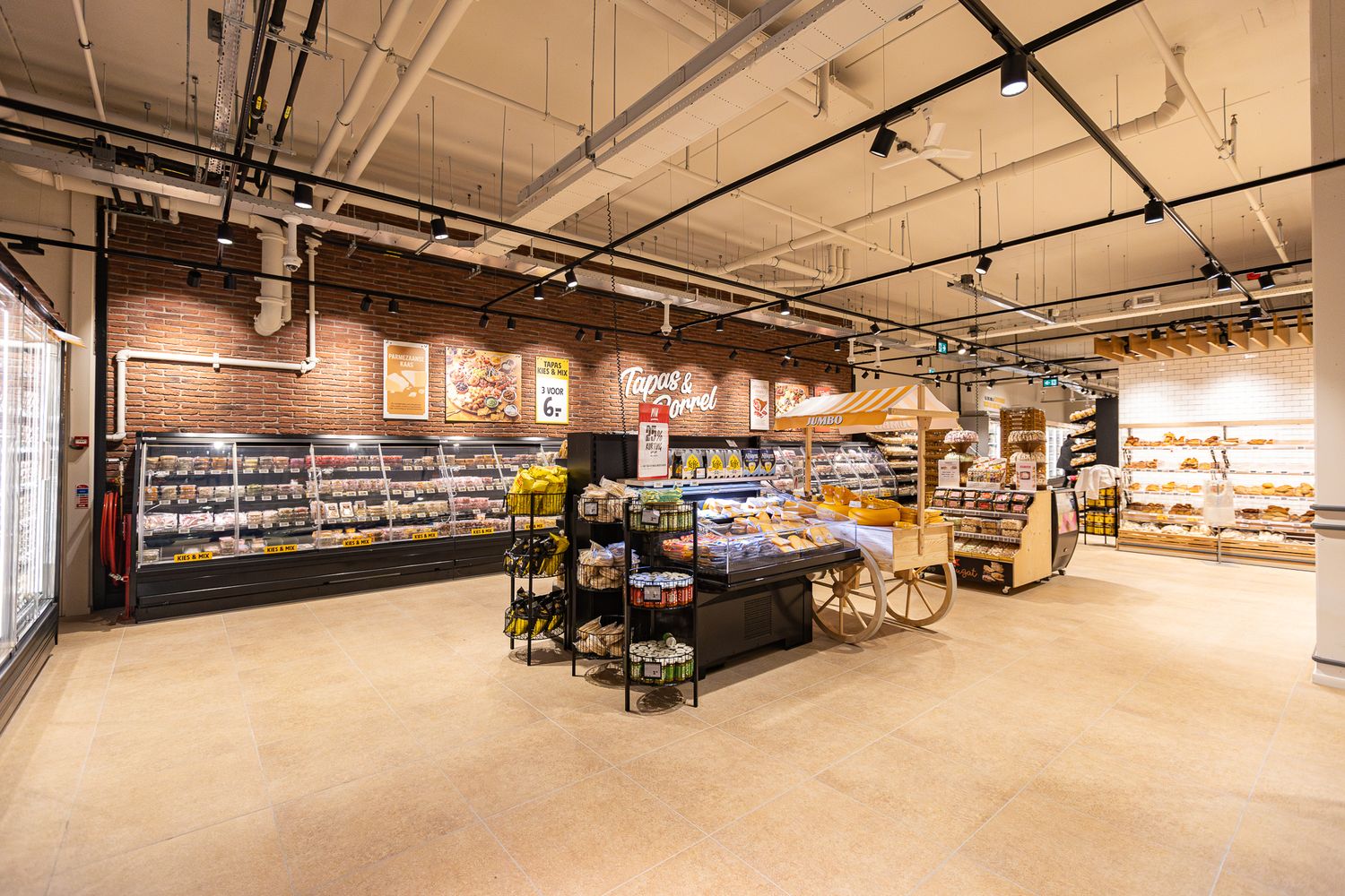 Modern grocery store interior with exposed brick walls, industrial ceiling, and well-stocked shelves of food products.