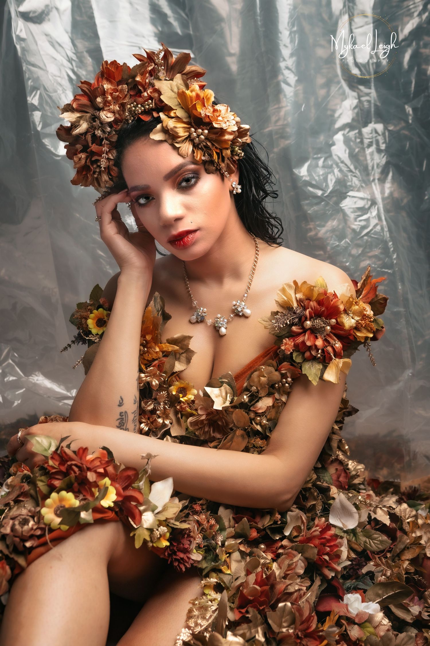Elegant portrait with bronze floral headpiece and matching dress against silver backdrop.