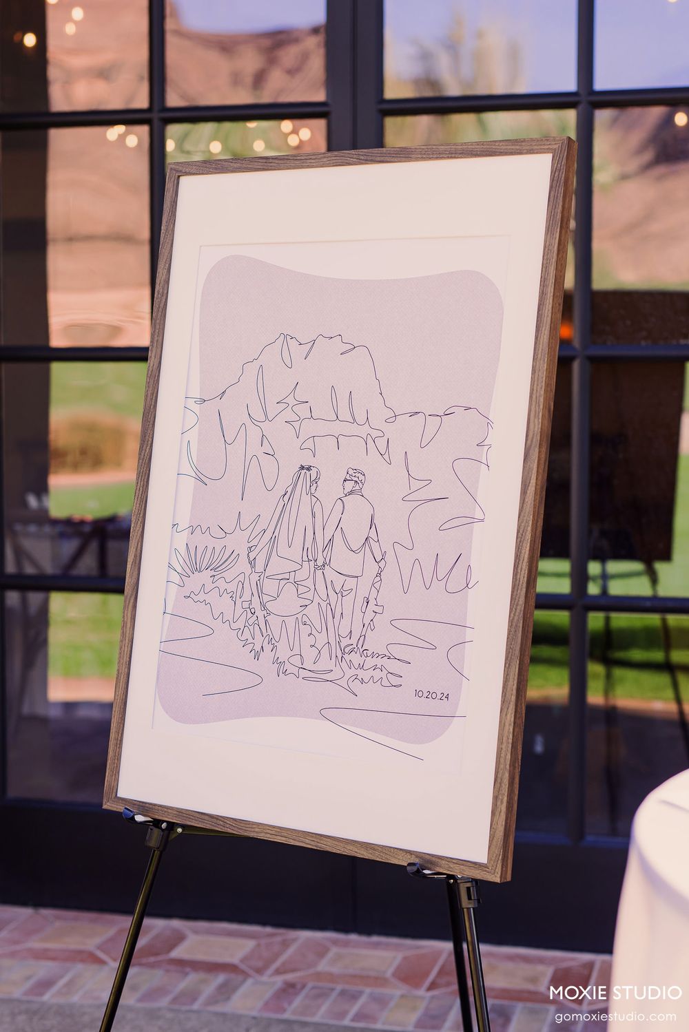 A series of simple line drawings displayed on easels showing abstract landscape sketches.