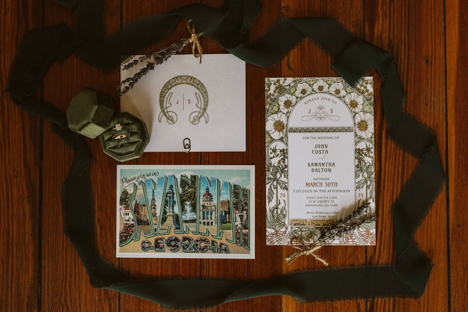 Vintage wedding invitations and postcards displayed on dark wooden surface.
