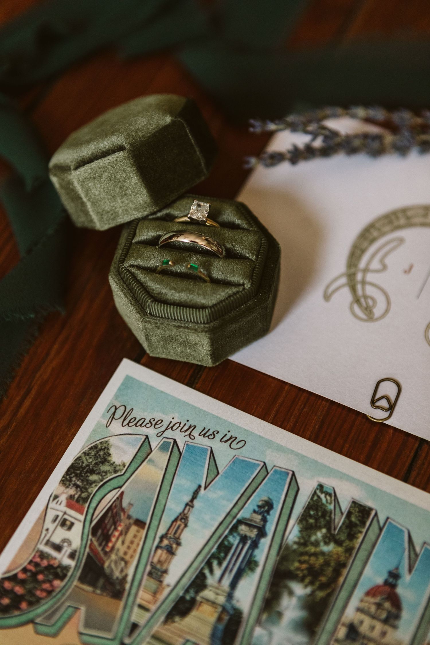 Elegant wedding invitations with green velvet ring boxes and decorative details.