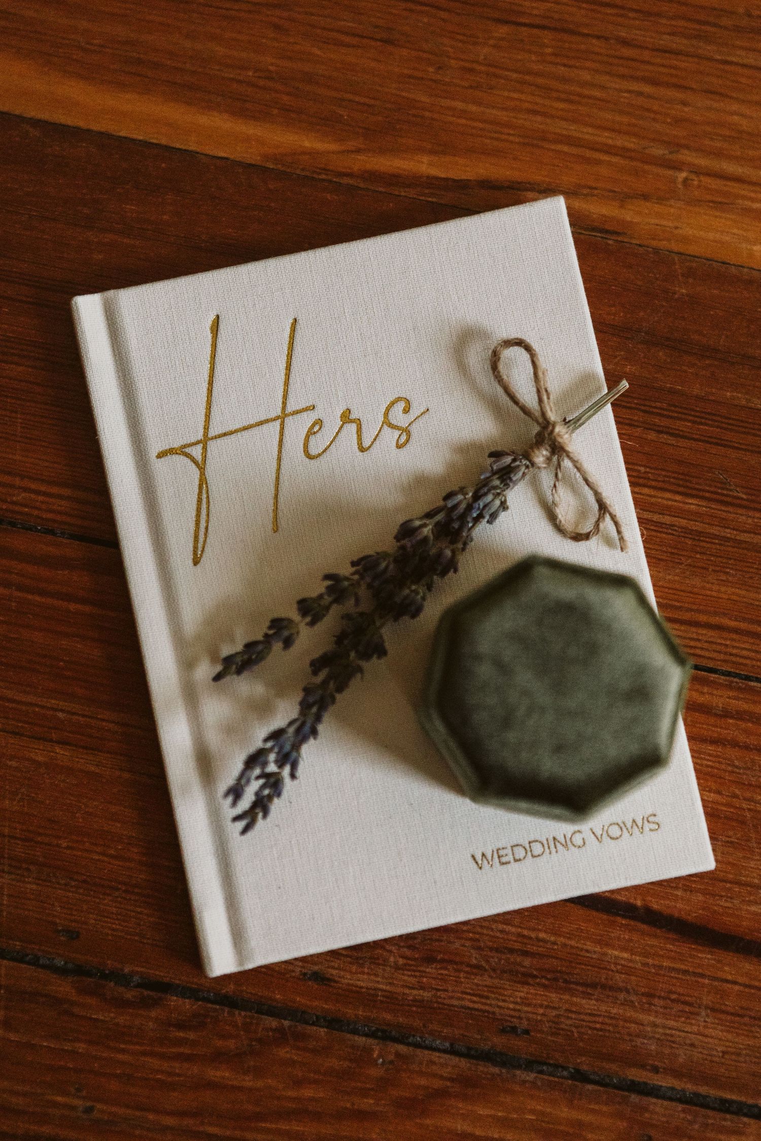 White wedding vow book decorated with dried lavender and sage green velvet box.