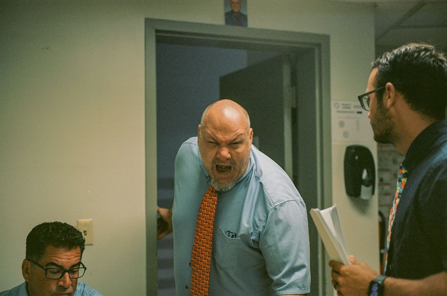 Animated office interaction captured on film in an indoor workspace.