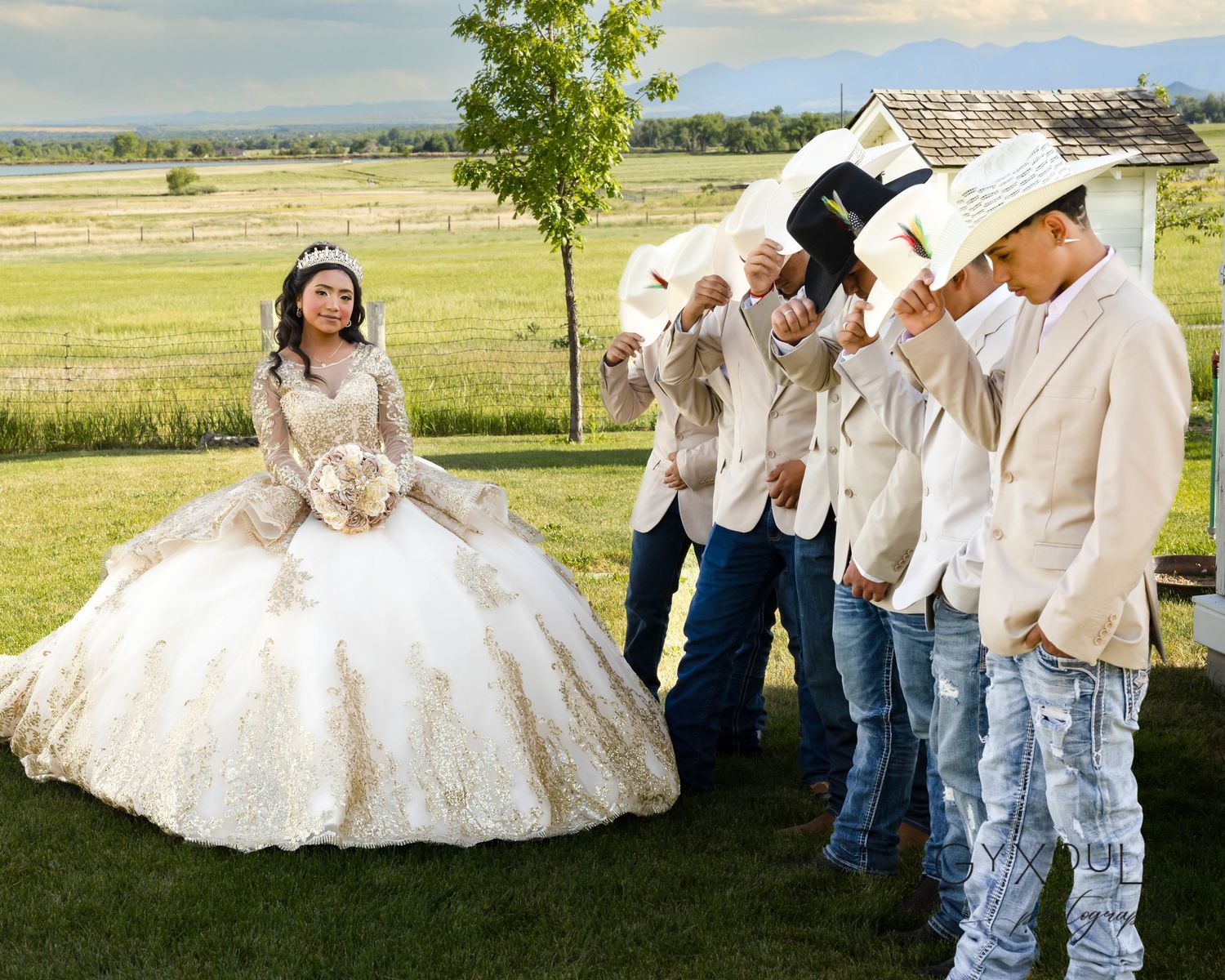 A quinceañera celebration with the guest of honor in a white ballgown surrounded by guests in cowboy attire.