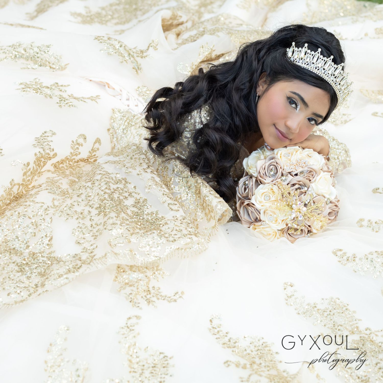 A classic quinceañera photo showcasing an embellished gold gown and cream-colored bouquet.