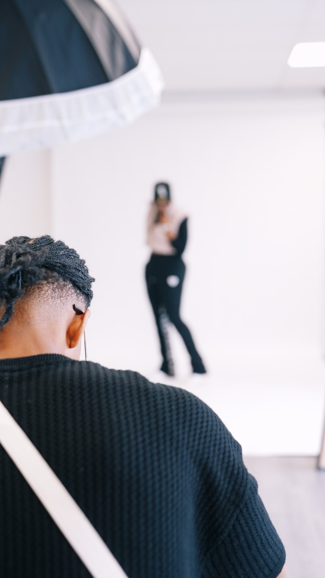 Behind-the-scenes view of a photo shoot in a bright white studio setting.