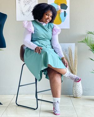 A mint green dress with white puff sleeves styled casually with patterned socks.