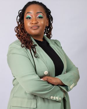 Professional portrait featuring a mint green blazer paired with a black top against a light background.