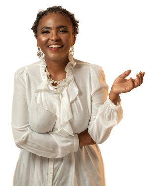 Portrait of someone in a white ruffled blouse and jewelry against white background.