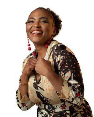 Joyful portrait wearing floral dress and red statement earrings.