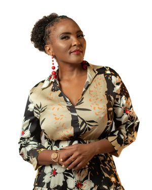 Elegant pose in floral print dress with statement red earrings.
