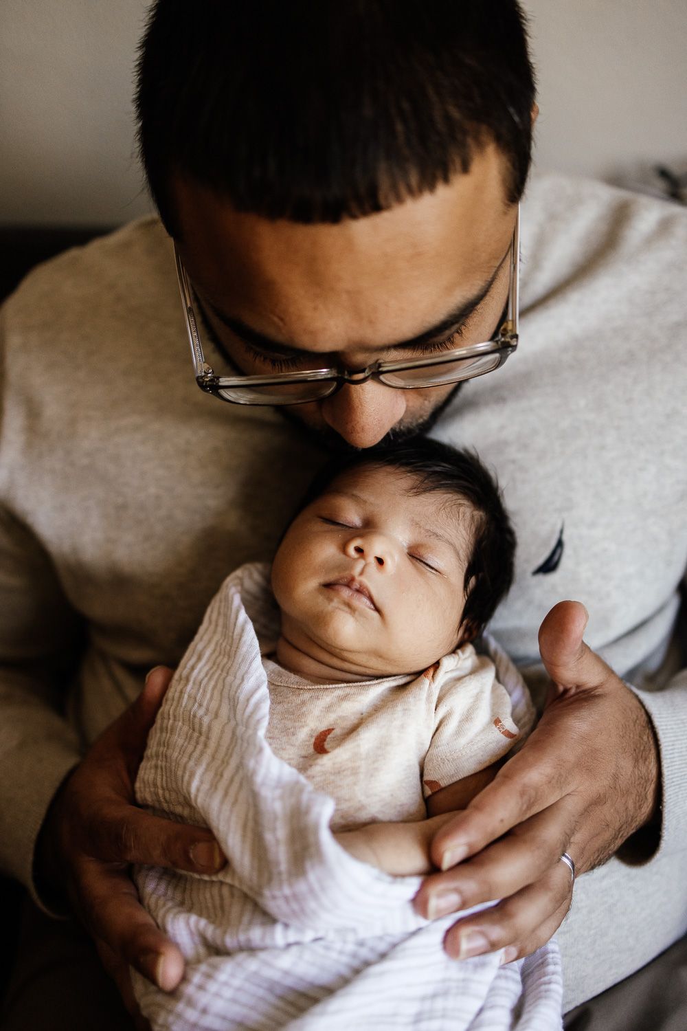 Bay Area Photographer Cindy Tucey does lifestyle in-home newborn photoshoot in San Jose where dad kisses baby's head